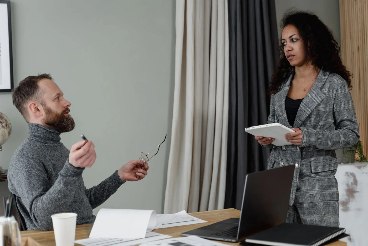 Two colleagues in discussion at a work table