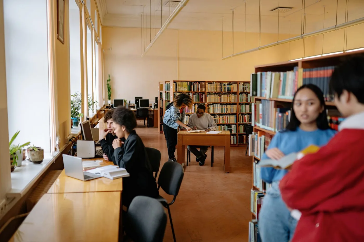 Students studying at tables in a university library