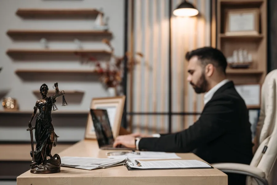 IP professional working on a laptop beside a Lady Justice statue